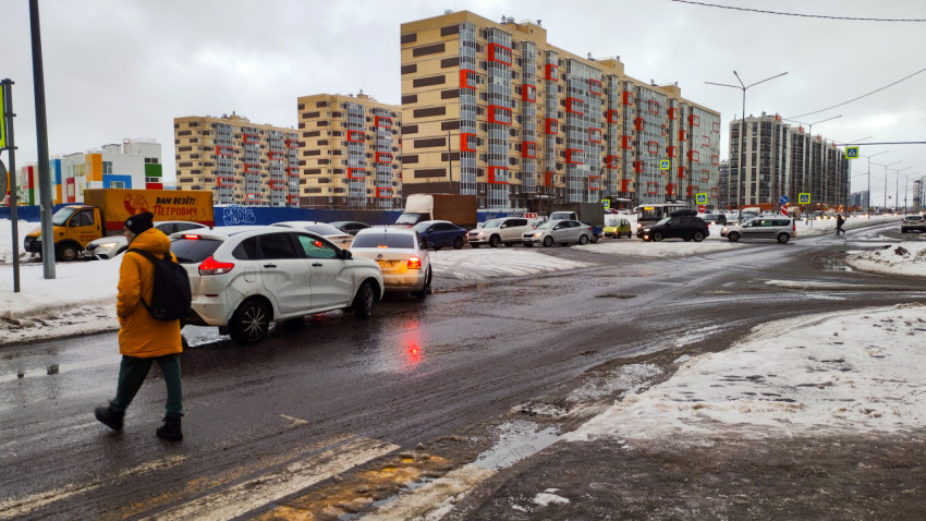 Городской пейзаж с автомобилями и снегом на улицах