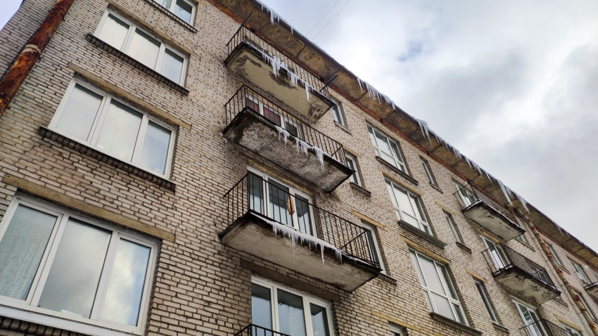 Зимние сосульки на балконах и крыше многоэтажного дома