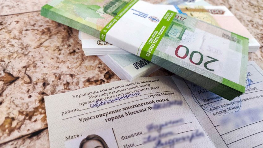 Удостоверение многодетной семьи и деньги на фоне плитки