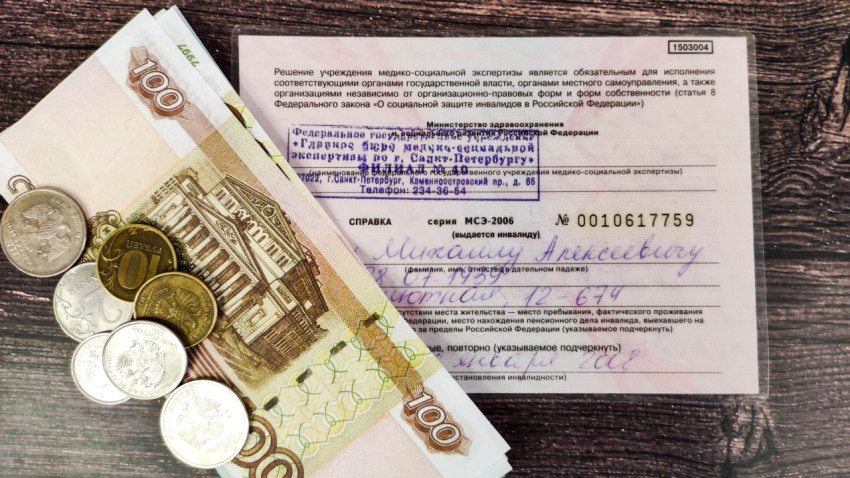 Удостоверение инвалида и деньги на столе