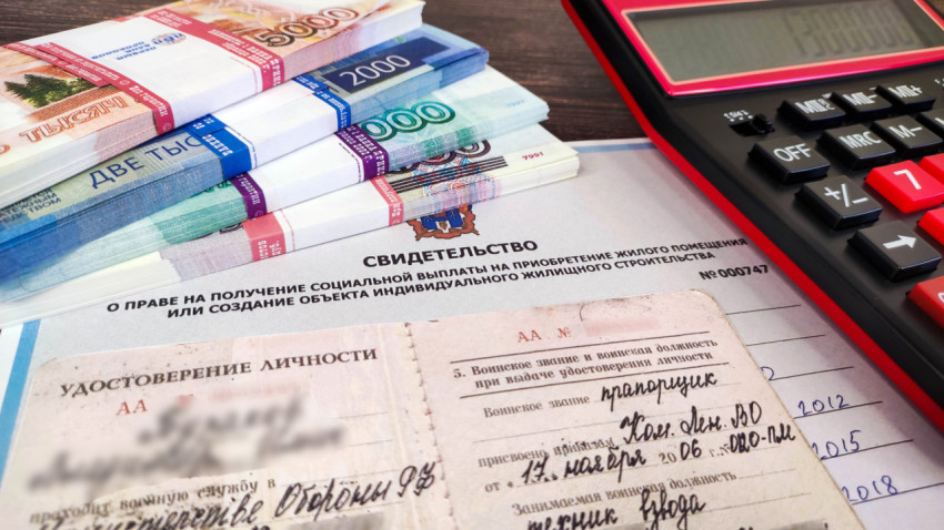 Сертификат на жилье, удостоверение личности военнослужащего, калькулятор и деньги на столе