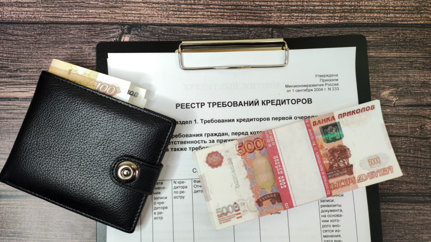 Кошелёк с купюрами на фоне реестра требований кредиторов