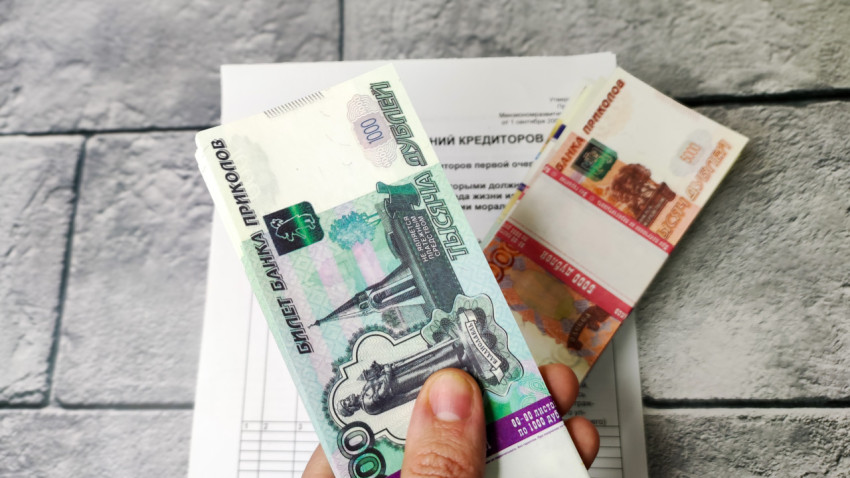 Купюры на фоне листа с реестром требований кредиторов