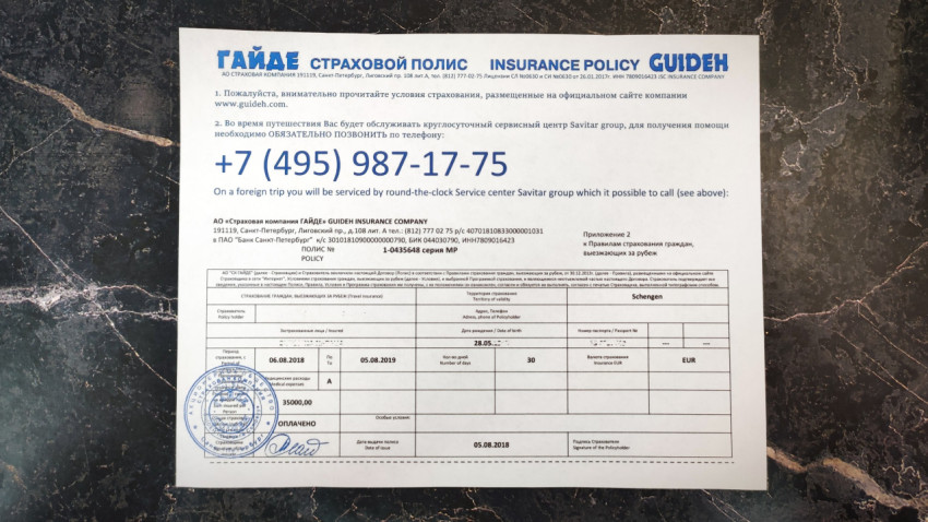 Полис страхования GUIDEH на фоне мраморной поверхности
