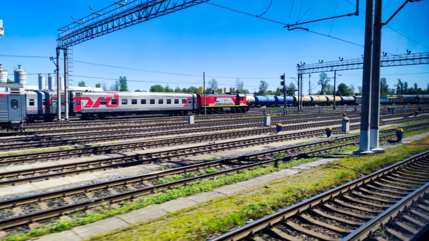 Пассажирские вагоны и маневровый тепловоз РЖД на железнодорожных путях