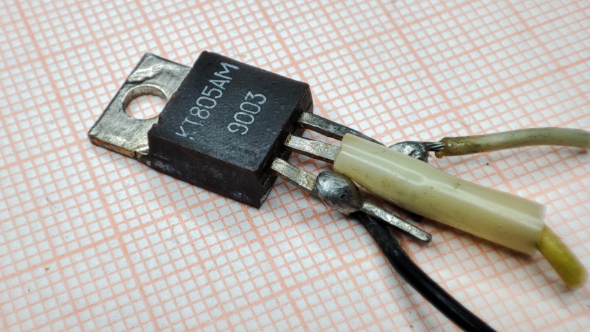 Транзистор КТ805АМ на миллиметровой бумаге с припаянными проводами
