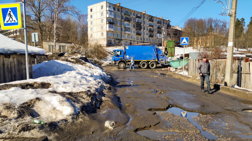 Грузовик для мусора забирает отходы на улицах города