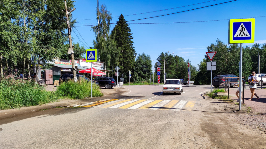 Пешеходный переход и дорожные знаки на улице в солнечный день