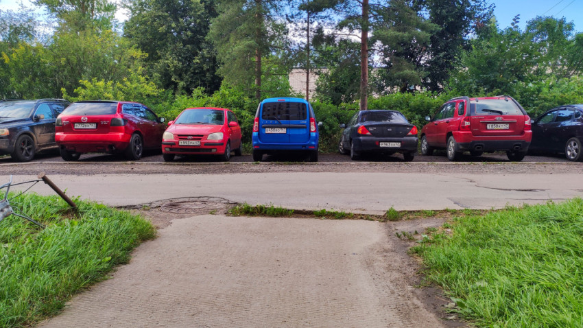 Парковка у жилого дома с припаркованными автомобилями