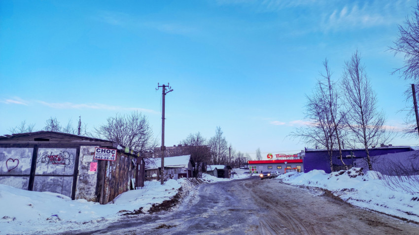 Зимняя улица с гаражами и магазином в жилом районе