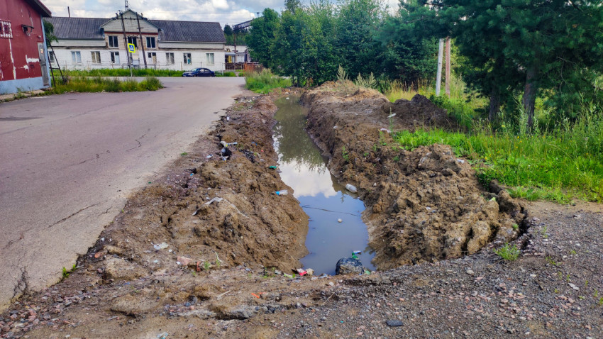 Канава с водой вдоль асфальтовой дороги