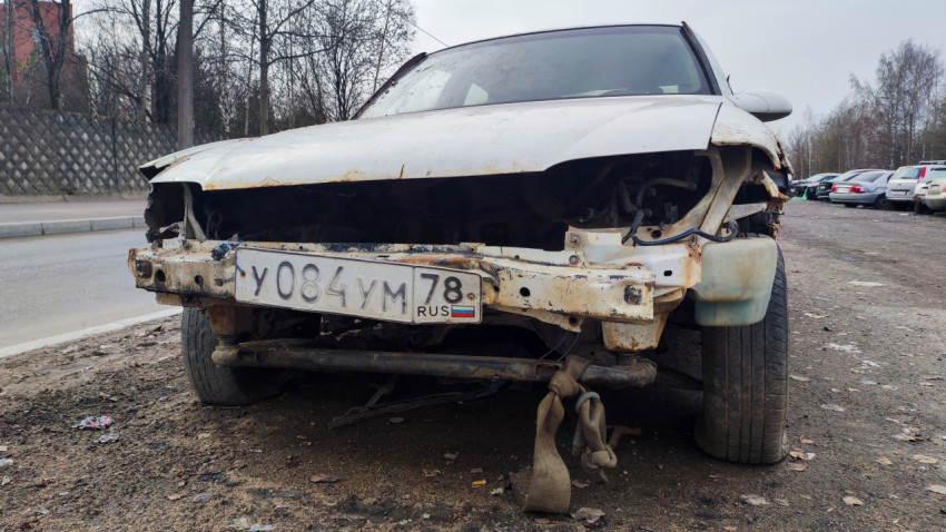 Повреждённый автомобиль без бампера на обочине дороги