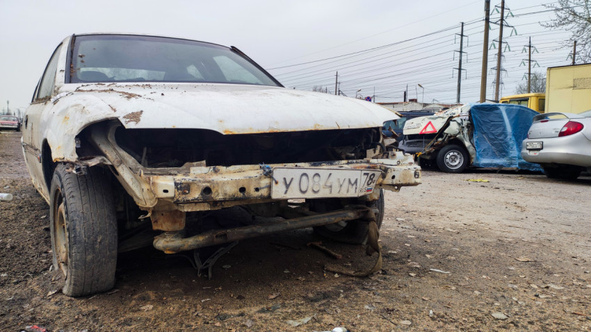 Повреждённый автомобиль с отсутствующим передним бампером на стоянке