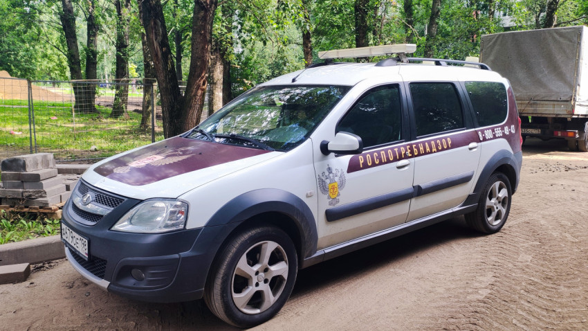 Служебный автомобиль Роспотребнадзора LADA Largus на грунтовой дороге в зелёной зоне