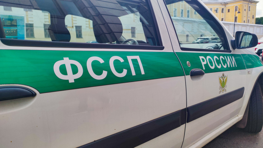 Логотип и зелёная полоса «ФССП России» на кузове служебного автомобиля