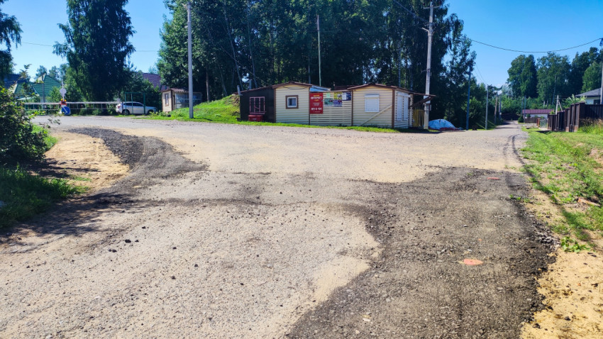Развилка дорог у модульных строений с объявлениями в пригородном посёлке