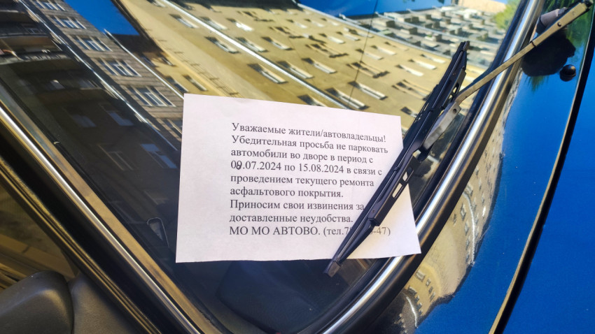 Объявление о запрете парковки на лобовом стекле автомобиля из-за ремонта асфальта во дворе