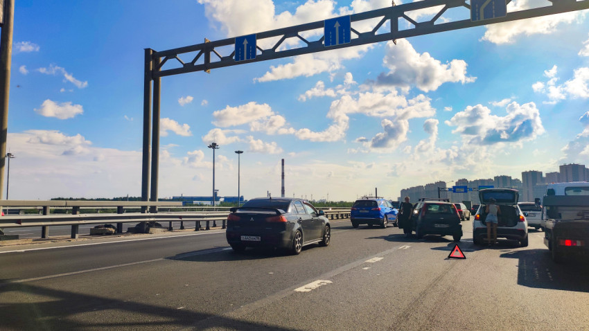 Остановка автомобилей на многополосной трассе с аварийным треугольником и указателями полос
