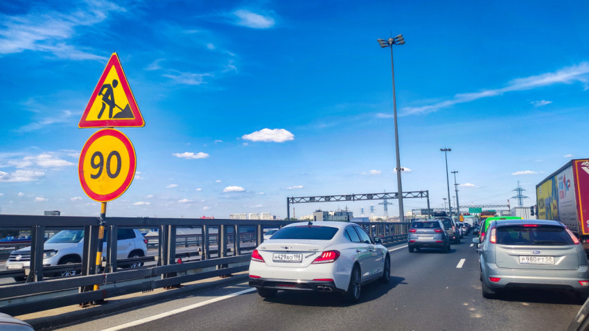 Дорожные знаки «Дорожные работы» и «90» на участке автомагистрали с плотным трафиком