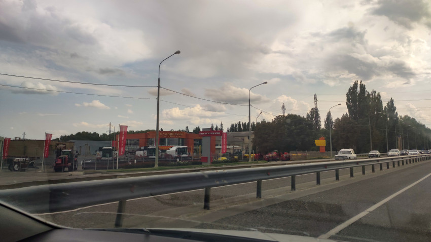 Придорожный вид на трассу с барьерным ограждением и съездом к техцентру