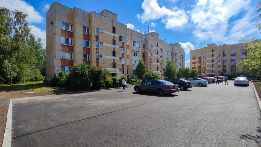 Новая асфальтовая парковка во дворе многоквартирного дома