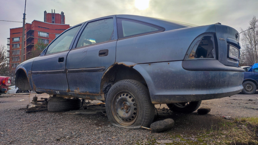 Повреждённый Opel Vectra на фоне кирпичного здания